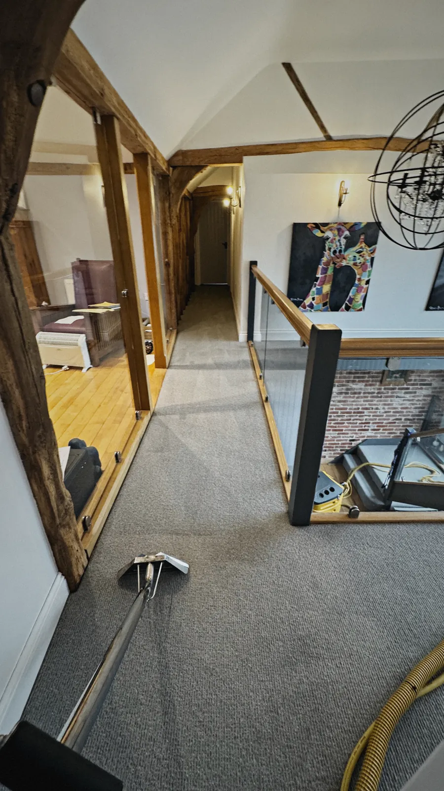 FIBRE & CO. carpet cleaning in progress on a grey loop-pile carpet across a beamed oak landing